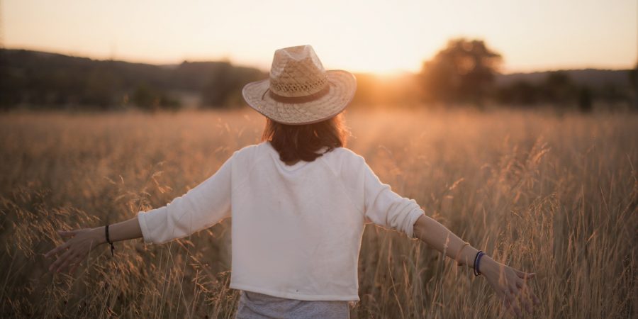 The Power of choice. A woman walking in the field at sunset.